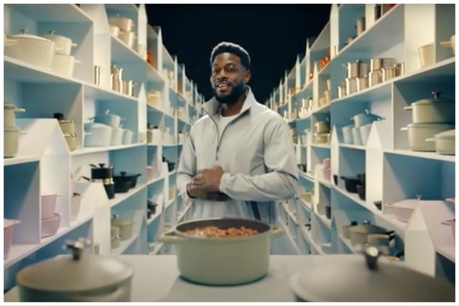 A man next to a pot of food in a kitchen showroom