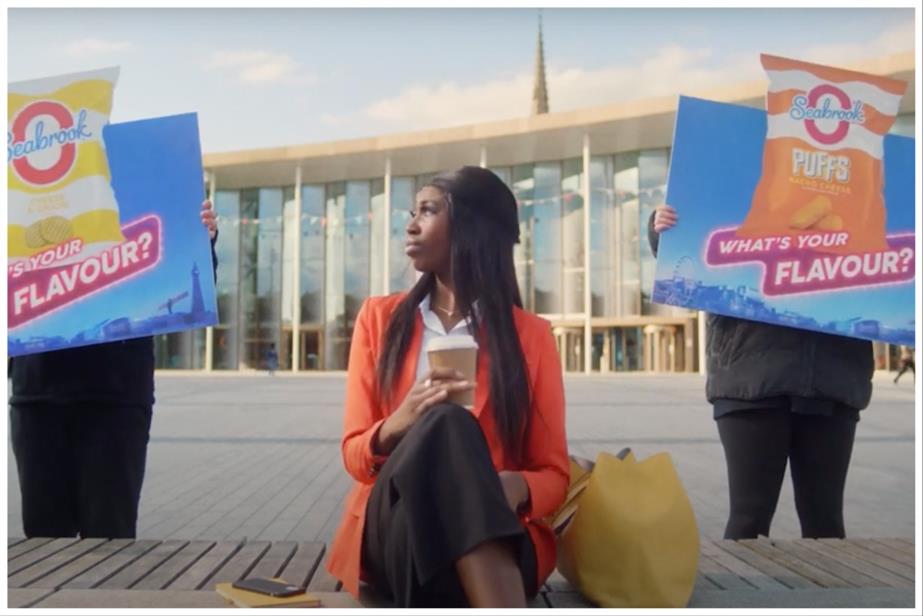 A woman sitting on a bench flanked by people holding placards