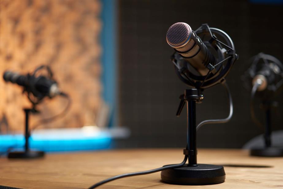 A close-up picture of three microphones in a podcasting studio