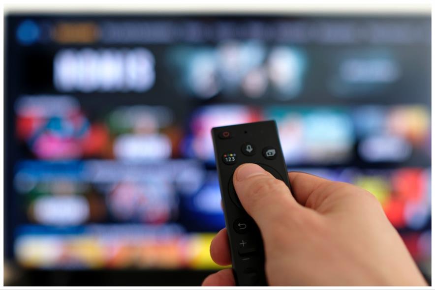 A picture showing a hand holding a TV remote control